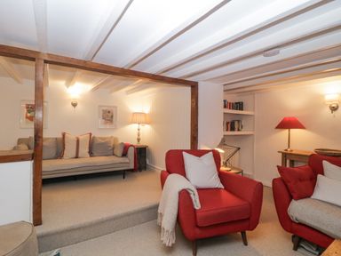 A living room with two red armchairs and a beige sofa with cushions at Springfield in Kingsand
