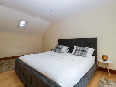 A bedroom with a bed and bedside table at Heathcliffe House in Castleton near Cardiff