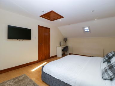 A bedroom with a bed and a television at Heathcliffe House in Castleton near Cardiff