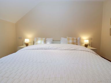 A bedroom with a bed and bedside lamps at Heathcliffe House in Castleton near Cardiff