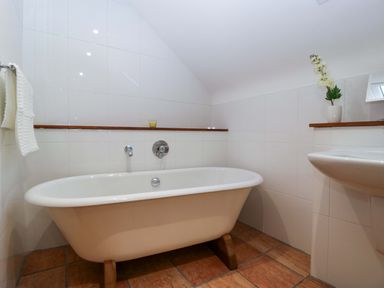 A bathroom with a bathtub and sink at Heathcliffe House Caslteton near Cardiff