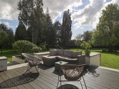 An outdoor seating area with a sofa, chairs and a table at Heathcliffe House in Castleton near Cardiff