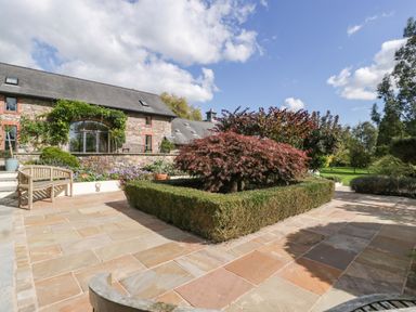 A garden area with trees and a house at Heathcliffe House Caslteton near Cardiff