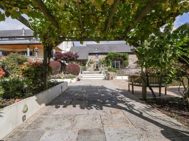 A garden view with seating area and pathway at Heathcliffe House Caslteton near Cardiff