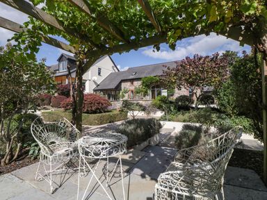 A garden with wrought iron furniture and flowers at Heathcliffe House Caslteton near Cardiff