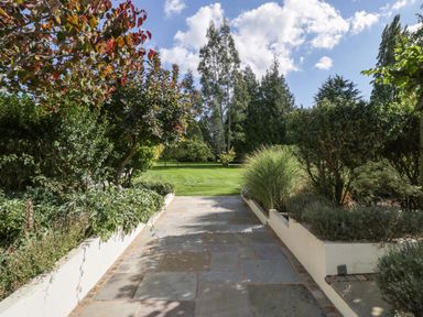 A garden pathway leading to a grassy area at Heathcliffe House in Castleton near Cardiff