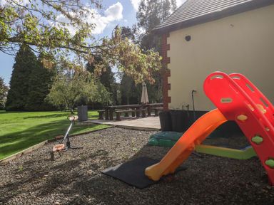 A garden with a slide and scooter at Heathcliffe House Castleton near Cardiff