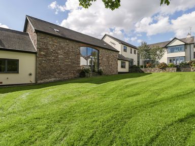 An outdoor view of a house with a lawn at Heathcliffe House, Caslteton near Cardiff