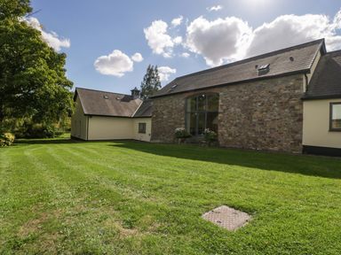 An outdoor view of a house with a garden at Heathcliffe House in Castletown near Cardiff