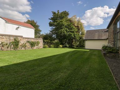 A garden with trees and grass at Heathcliffe House Caslteton near Cardiff