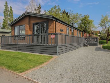 A house with a deck and grass area at Peony in Eardisland