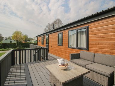 A deck area with seating and a table at Peony in Eardisland