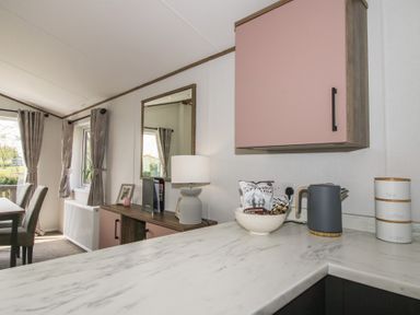 A dining room with a table and chairs and a window at Peony in Eardisland