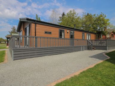 A cabin with a deck and gravel area at Peony in Eardisland