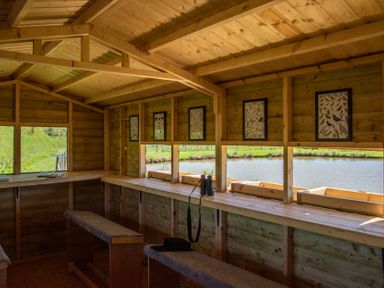 An observation room with wooden bench and binoculars at Peony in Eardisland