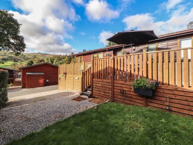 A decking area with steps and a planter at Swifts Reach Lodge, Kirkstone 10, Limefitt Park near Windermere