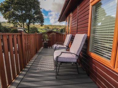 A deck with chairs and a planter at Swifts Reach Lodge near Kirkstone 10, Limefitt Park near Windermere