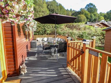 An outdoor area with a table and chairs under an umbrella at Swifts Reach Lodge Kirkstone 10, Limefitt Park near Windermere