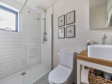 A bathroom with shower, sink, and toilet at Grove Cottage in Kington