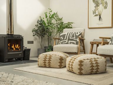 A living room with a fireplace and armchairs at Grove Cottage in Gladestry