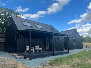 A house with a deck and chairs at Grove Cottage in Gladestry