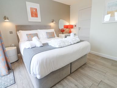 A bedroom with a bed and bedside table with a lamp at Hepworth in Portreath