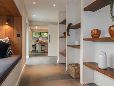 A hallway with shelves and seating area at Harberton