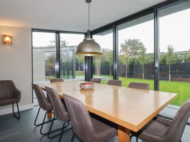 A dining room with a wooden table and chairs at Harberton