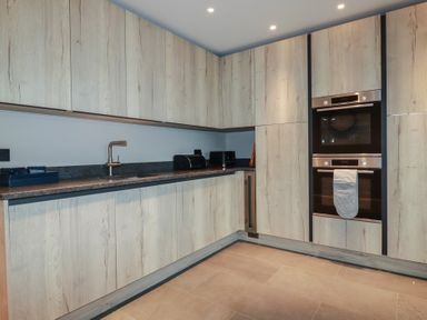 A kitchen with cabinets and two ovens at Harberton