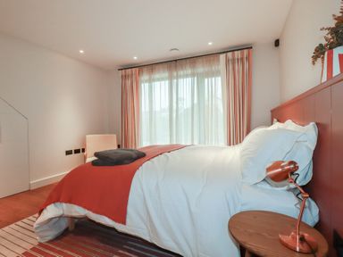 A bedroom with a bed and bedside table at Harberton