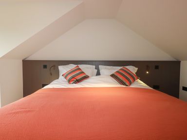 A bed with pillows and a lamp at Harberton