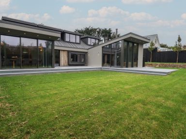 A modern house with large glass windows and a patio at Harberton