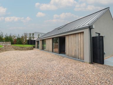 An exterior view of a house with gravel driveway at Harberton