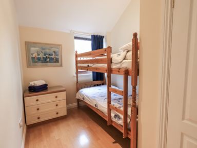 A bedroom with a bunk bed and dresser at Millers Cottage Seaville near Wigton