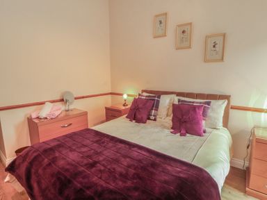 A bedroom with a bed and bedside tables at The Hayloft near Wigton