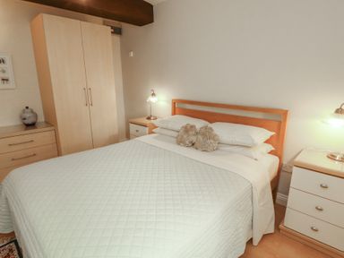 A bedroom with a bed and wardrobe at The Coach House near Wigton