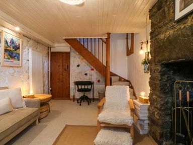 A living room with a sofa and fireplace at Waterfall Retreat in Blaenau Ffestiniog
