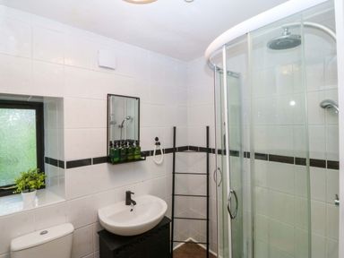 A bathroom with a shower, toilet, and sink at Waterfall Retreat in Blaenau Ffestiniog