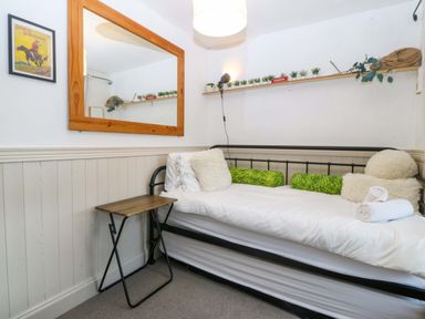 A bedroom with a bed, mirror, and table at Waterfall Retreat in Blaenau Ffestiniog