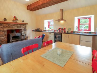 A kitchen with dining table and stove at Shane's Cottage in Falcarragh, County Donegal
