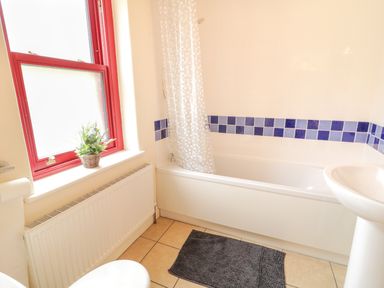 A bathroom with a bathtub and sink at Shane's Cottage in Falcarragh, County Donegal