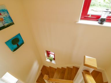 A staircase with paintings on the wall at Shane's Cottage, Falcarragh, County Donegal