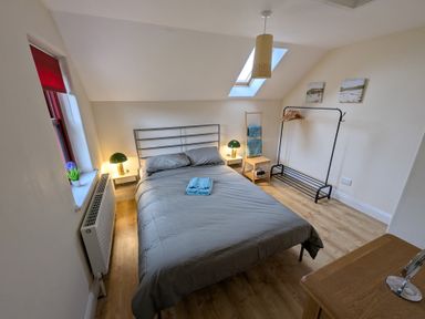 A bedroom with a bed and a bedside lamp at Shane's Cottage in Falcarragh, County Donegal