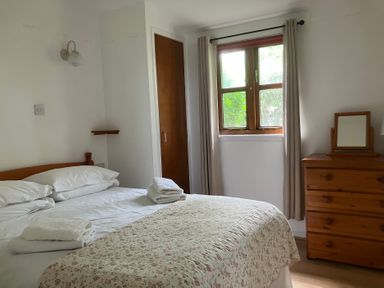 A bedroom with a bed and dresser at Island View Lodge Back of Keppoch near Arisaig