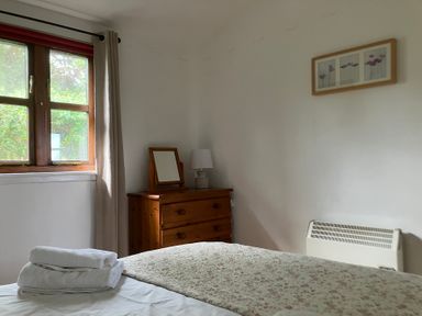 A bedroom with a bed and a chest of drawers at Island View Lodge in Back of Keppoch near Arisaig