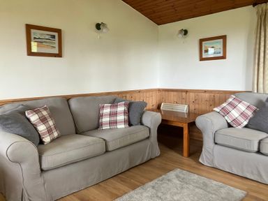 A living room with sofas and wooden table at Island View Lodge in Back of Keppoch near Arisaig