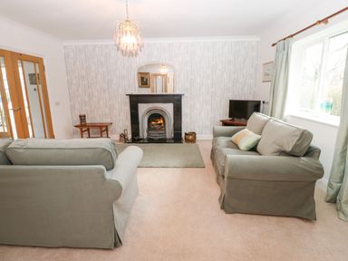 A living room with two sofas a fireplace and a television at Kerangarth in Corbridge