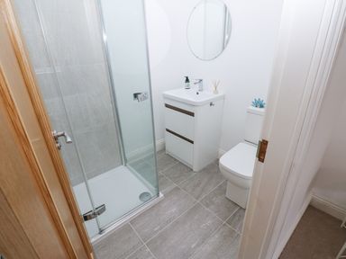 A bathroom with a shower enclosure a vanity unit with a sink and a toilet at Kerangarth in Corbridge