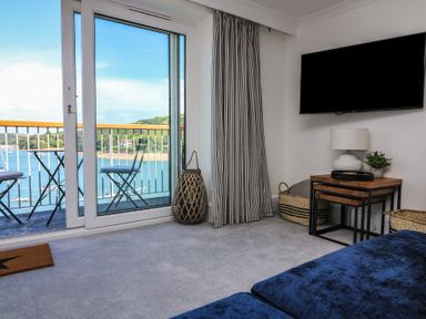 A living room with a sofa and a television at 43 The Salcombe in Salcombe