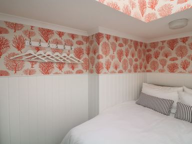 A bedroom with a bed and coat rack at 43 The Salcombe in Salcombe